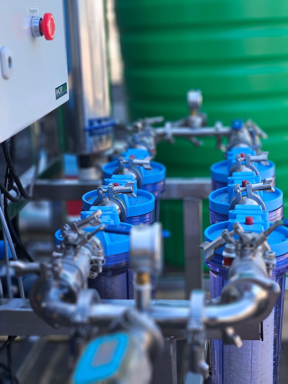 Filtros y válvulas industriales instalados como parte de una planta de tratamiento de agua, conectados mediante tuberías metálicas.